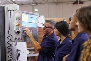 Engineer Training Apprentices On CNC Machine