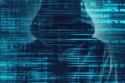 image of Cybersecurity, computer hacker with hoodie and obscured face, computer code overlaying image