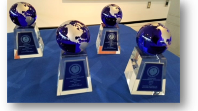 Trophies with planet earth perched on a base are arranged on a table.