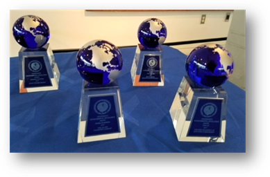 Trophies with planet earth perched on a base are arranged on a table.