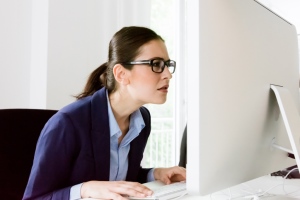 Woman squinting at a computer screen