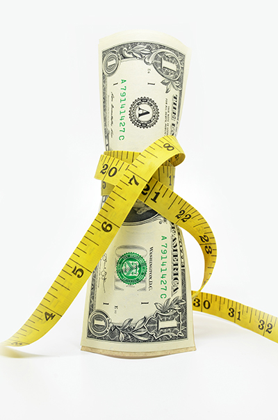 image of dollar bill being squeezed by tape measure