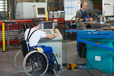 photo of disabled worker in wheelchair in factory on the machine